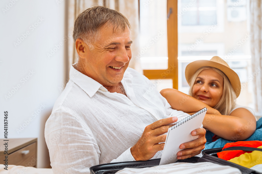 Preparation is important before the trip. A man and a woman with a suitcase are preparing for a summer vacation or travel. Preparation is important before the trip. A man and a woman with a suitcase are preparing for a summer vacation or travel.