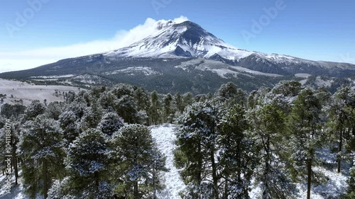 Drone footage of the mountains of central Mexico fully covered in snow, the most famous volcano of the country is visible at the background photo