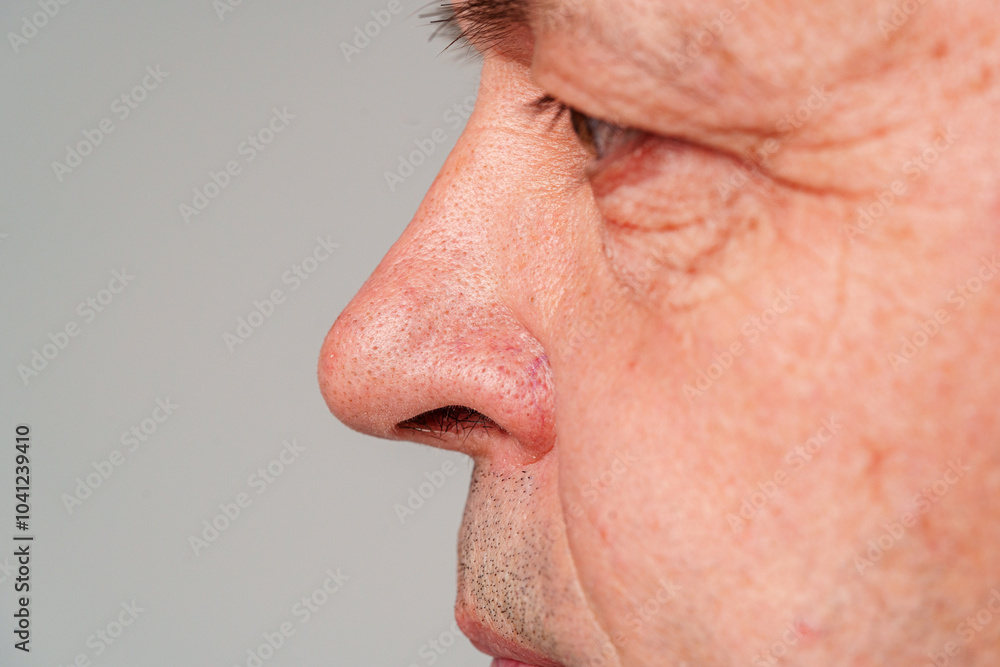 Fototapeta premium Portrait of a mature man with short hair and a neutral expression, captured in a studio setting