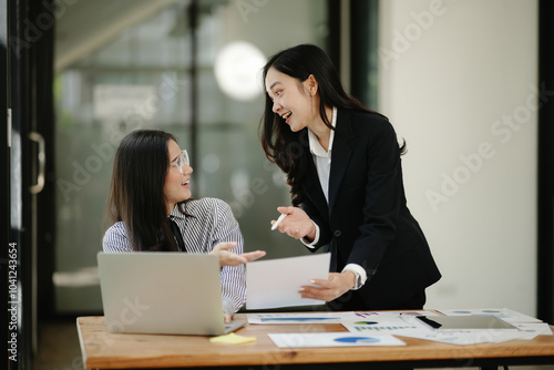 Asian business woman talking, working on graph documents