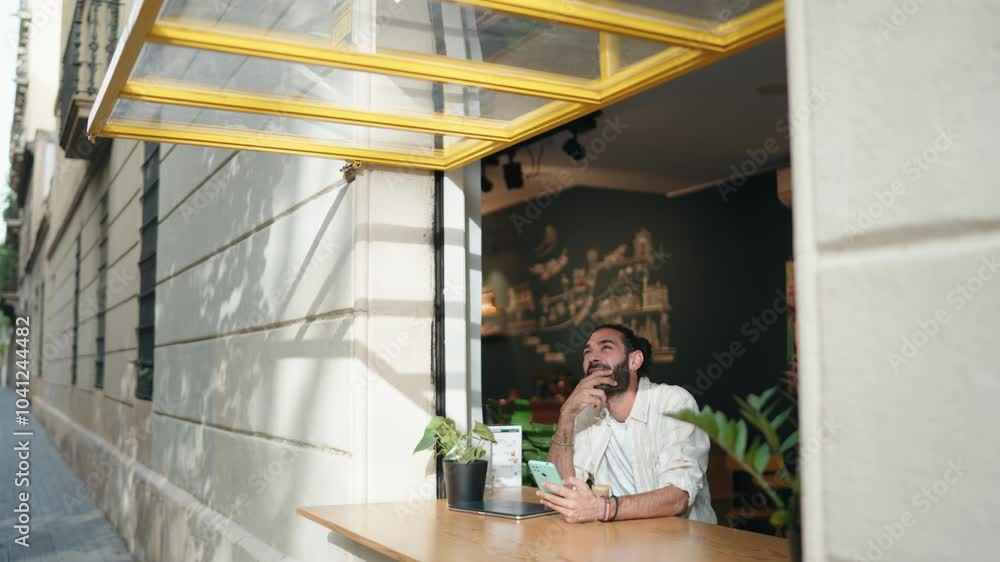 Smiling man sitting at café, engaged in lively online conversation through his mobile phone. Adult male enjoy staying connected anywhere through modern technology. Reading news in social media app
Smiling man sitting at café, engaged in lively online conversation through his mobile phone. Adult male enjoy staying connected anywhere through modern technology. Reading news in social media app