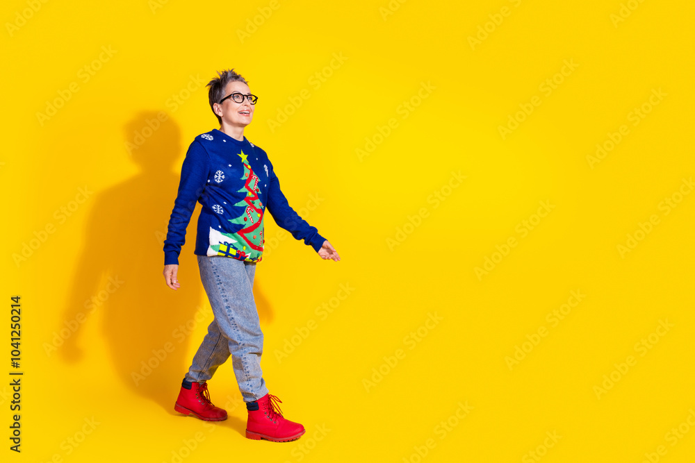 Photo of cheerful lovely senior woman wear blue stylish clothes going empty space isolated on yellow vivid color background Photo of cheerful lovely senior woman wear blue stylish clothes going empty space isolated on yellow vivid color background
