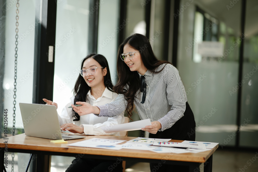 Asian business woman talking, working on graph documents Asian business woman talking, working on graph documents