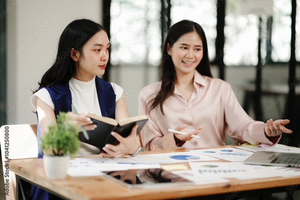 Asian business woman talking, working on graph documents Asian business woman talking, working on graph documents