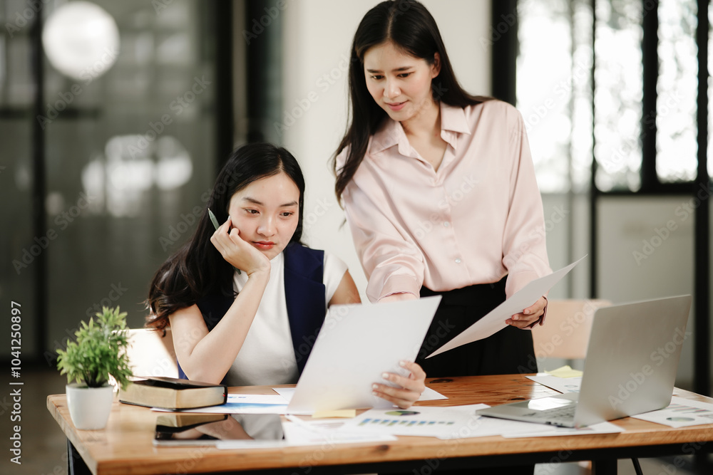 Asian business woman talking, working on graph documents Asian business woman talking, working on graph documents
