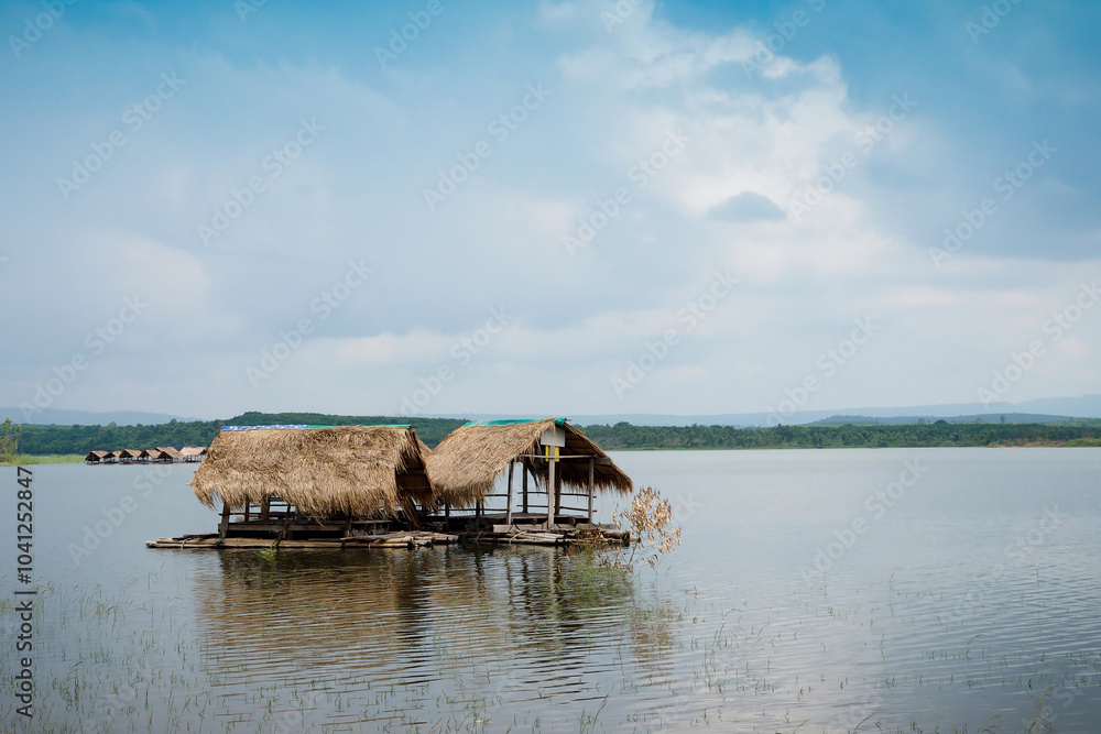 wooden hut with a thatched roof floating in the river wooden hut with a thatched roof floating in the river
