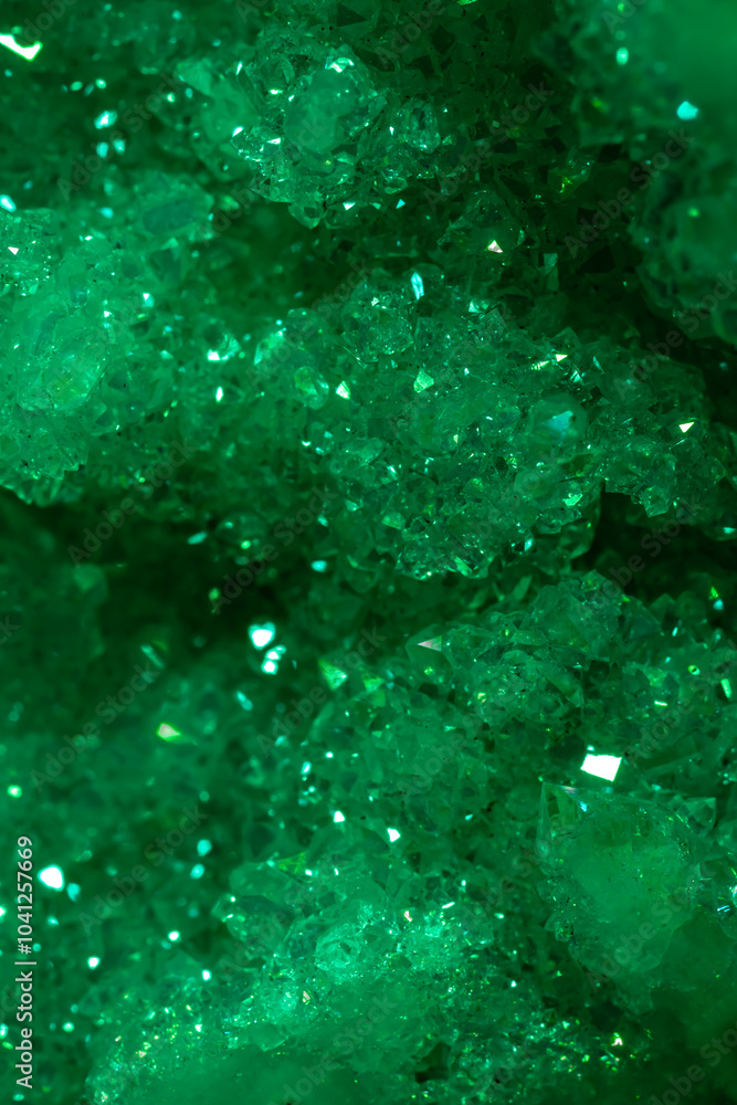Fototapeta premium Green crystal mineral stone. Gems. Mineral crystals in the natural environment. Texture of precious and semiprecious stones. Seamless background with copy space colored shiny surface of precious stone