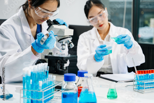 Asian Female Scientists Conducting Chemistry Research in Laboratory