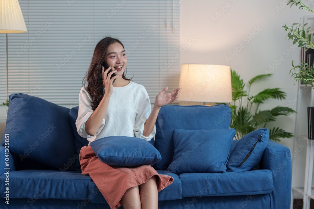 Cheerful Asian woman using mobile phone Chat on the website, application, download, work or study online. Sit on the sofa and relax. modern technology concept Cheerful Asian woman using mobile phone Chat on the website, application, download, work or study online. Sit on the sofa and relax. modern technology concept
