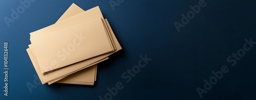 A stack of blank brown paper cards, postal envelopes on a dark blue background, viewed from above. The concept is for advertising and marketing, branding, or social media post design templates. 