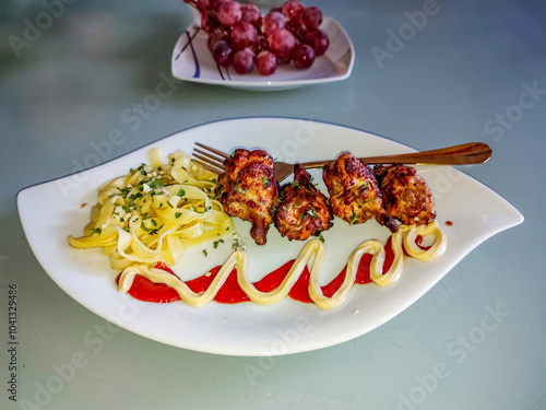 Plat de poulet et de pates dressé dans une assiette atypique  pour un repas non gastronomique mais appétissant et bien dressé photo