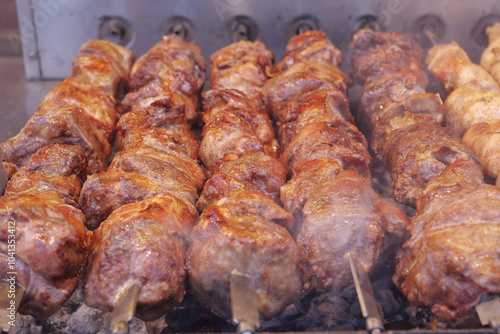 Kebabs on skewers are grilled on hot coals photo