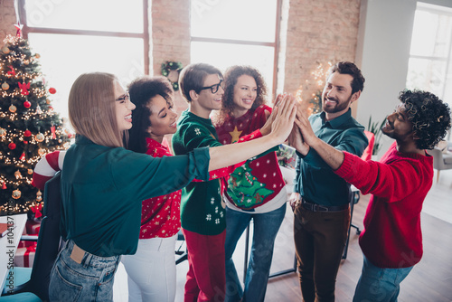 Obraz na plátně Photo of cheerful young people colleagues highfive help teamwork cozy christmas