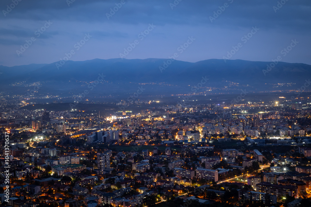 Fototapeta premium City illuminated at dusk, seen from above. The European capital of North Macedonia, Skopje.
