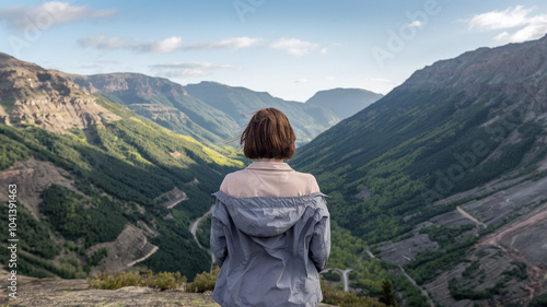 Woman Gazes at Mountainous Landscape From Peak