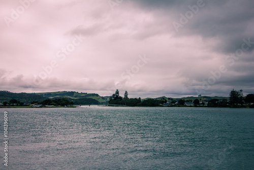 Retro style photo of a breathtakingly serene view of the lake under beautiful, cloudy skies. Raglan, New Zealand. Toned image photo