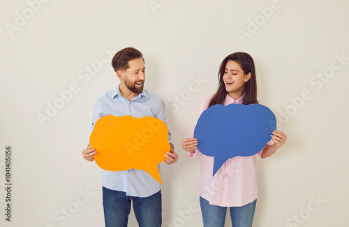 Obraz na plátně Holding paper speech bubbles couple playful banter faces smiling and joy