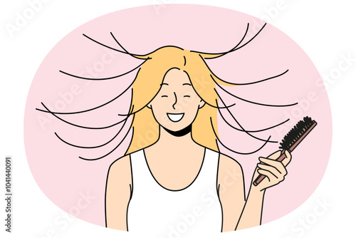 Woman combs hair and smiles, seeing effect of static magnetization of hairstyle. Funny young blonde girl takes care of own hair getting ready for date and laughing feeling surge of positive emotions