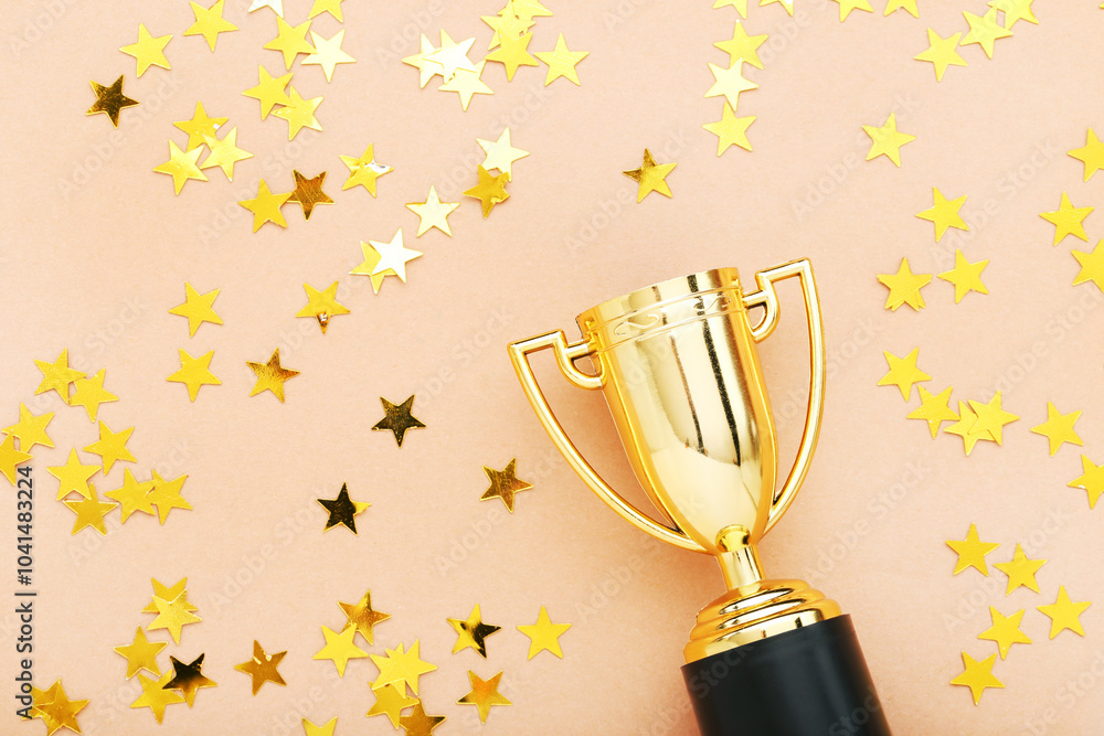 Golden trophy cup with confetti on beige background