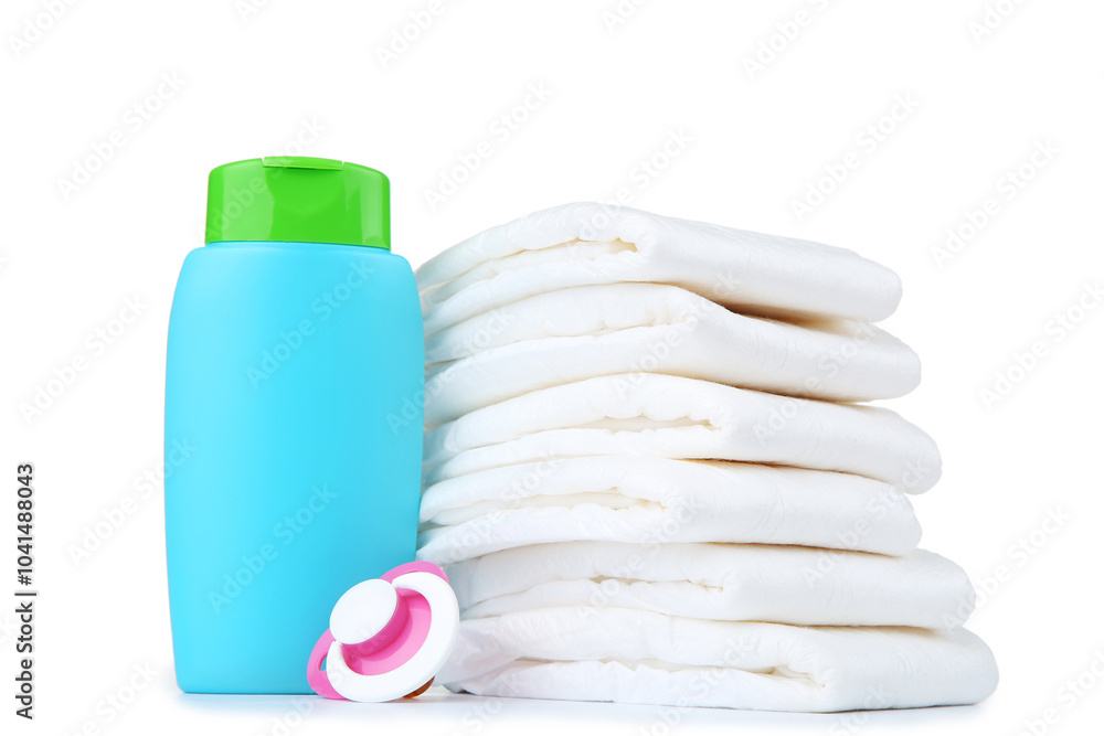 Baby diapers with bottle and pacifier on white background