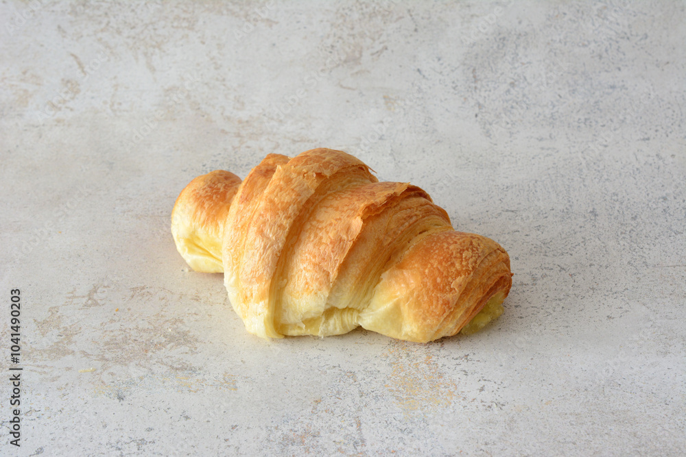 a croissant isolated on the marble background close up a croissant isolated on the marble background close up