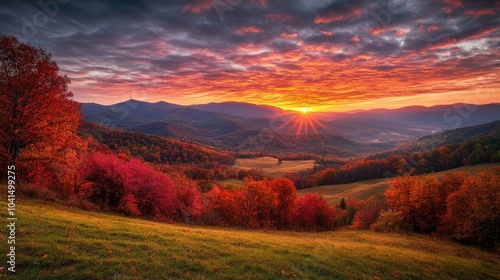 Stunning sunrise illuminates rolling hills adorned with vibrant autumn leaves and striking mountain silhouettes beneath a cloudy sky