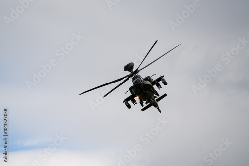 close-up of a British army Boeing Apache Attack helicopter gunship AH64E AH-64E ArmyAirCorp banking hard in low level overhead flight