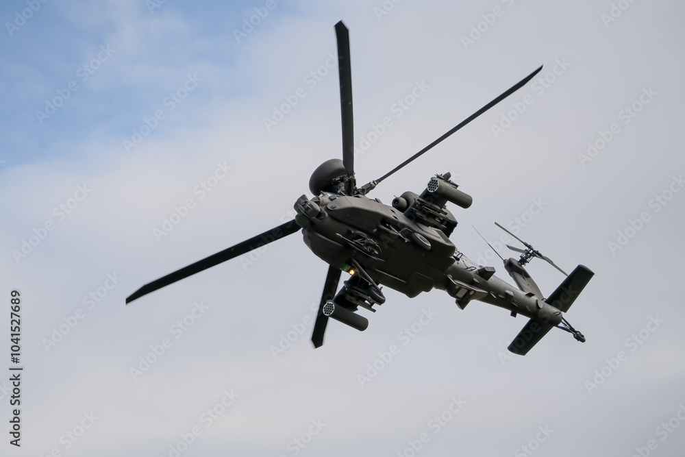 Fototapeta premium close-up of a British army Boeing Apache Attack helicopter gunship AH64E AH-64E ArmyAirCorp banking hard in low level overhead flight