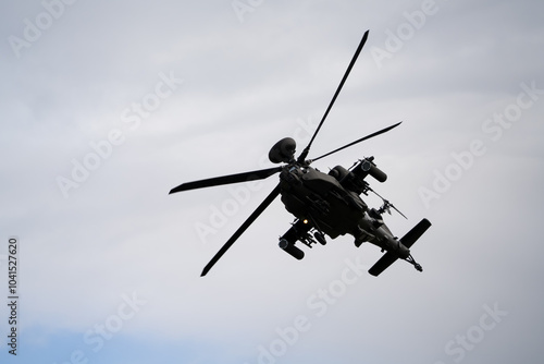 close-up of a British army Boeing Apache Attack helicopter gunship AH64E AH-64E ArmyAirCorp banking hard in low level overhead flight