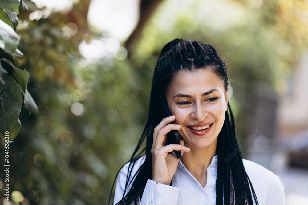 Business woman with braided hair talking on the phone outside the street Business woman with braided hair talking on the phone outside the street