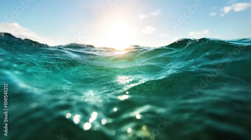 Vibrant ocean scene capturing the sunlit waves beneath a clear blue sky, showcasing the mesmerizing beauty and dynamic energy of the sea in motion.