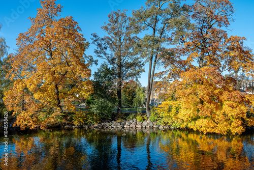 Autumn colors at Strömsholmen islet in Motala Stream during autumn in Norrköping, Sweden  photo