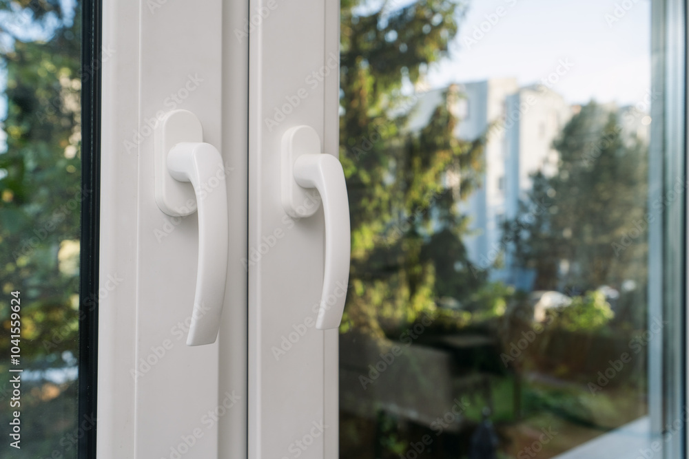 Close-up view of modern window handles in room with forest on backgrounds Close-up view of modern window handles in room with forest on backgrounds