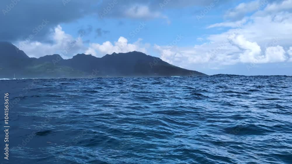 Aboard whale watching tour boat on rolling swell waves of ocean with view of Moorea Island in French Polynesia, South Pacific Aboard whale watching tour boat on rolling swell waves of ocean with view of Moorea Island in French Polynesia, South Pacific