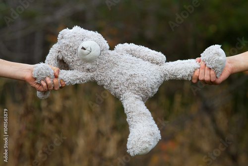 The hands of two children are pulling a toy