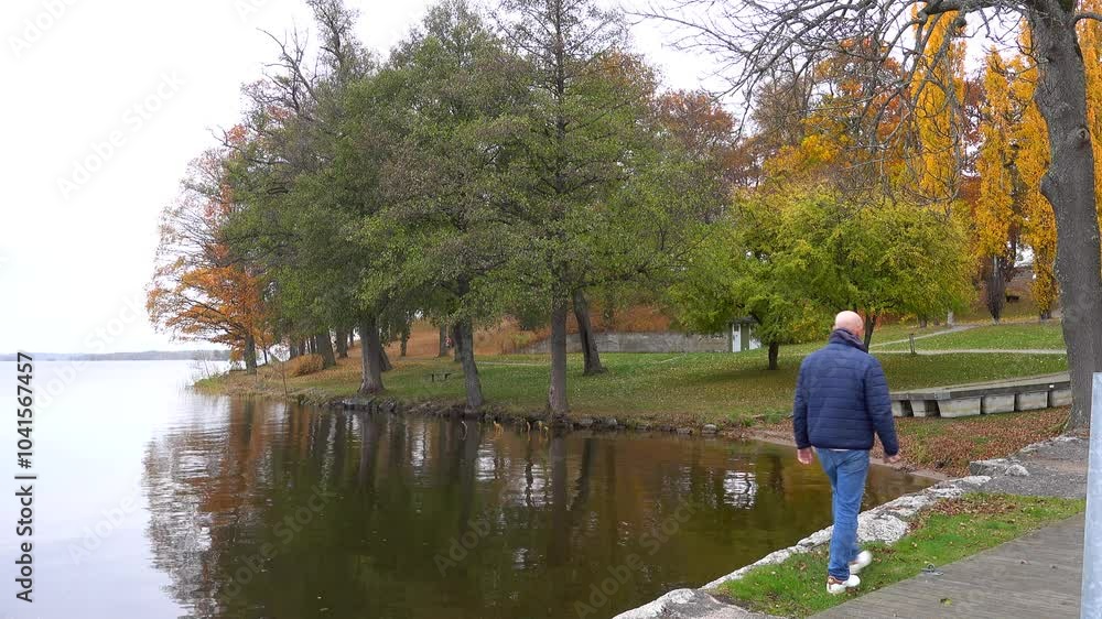 Nykvarn, Sweden A man walks alone in the park amidst autumn foliage on the shore of Lake Malaren. Nykvarn, Sweden A man walks alone in the park amidst autumn foliage on the shore of Lake Malaren.