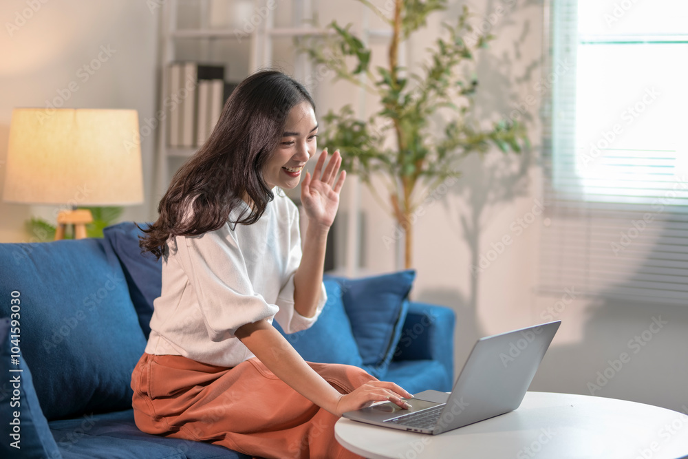 Young woman waving during video call on laptop at home Young woman waving during video call on laptop at home