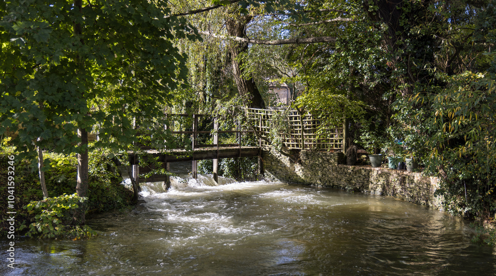 The River Churn as it flows through the Cotswold village of South Cerney in Gloucestershire, England, United Kingdom The River Churn as it flows through the Cotswold village of South Cerney in Gloucestershire, England, United Kingdom