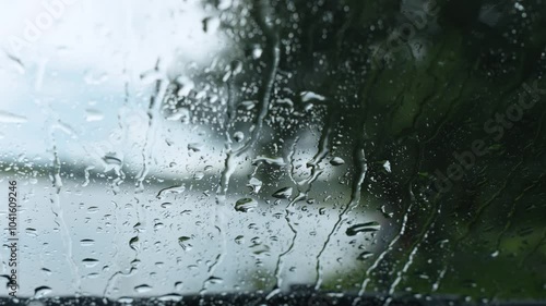 As raindrops race down a window, they leave behind a delicate, ever-changing pattern that captures the soothing rhythm and calming atmosphere of a rainy day, inviting quiet contemplation.