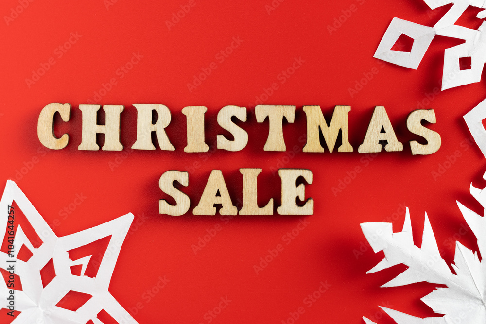 christmas sale wording with paper cut out snowflakes on red background. selective focus christmas sale wording with paper cut out snowflakes on red background. selective focus