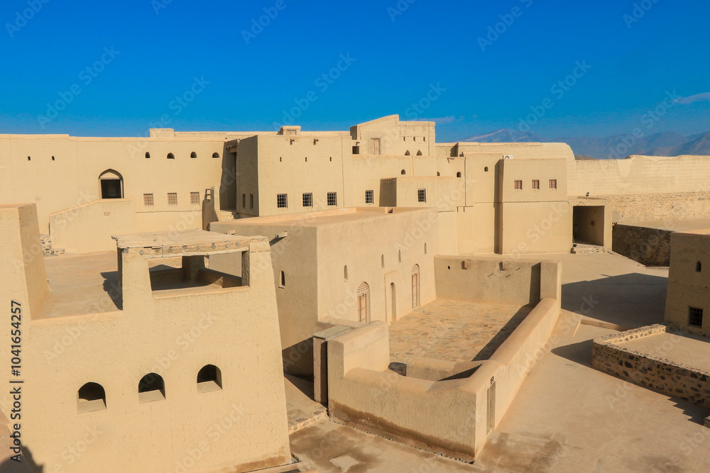 Bahla Fort in Oman showcasing ancient architecture under a clear blue sky during midday Bahla Fort in Oman showcasing ancient architecture under a clear blue sky during midday