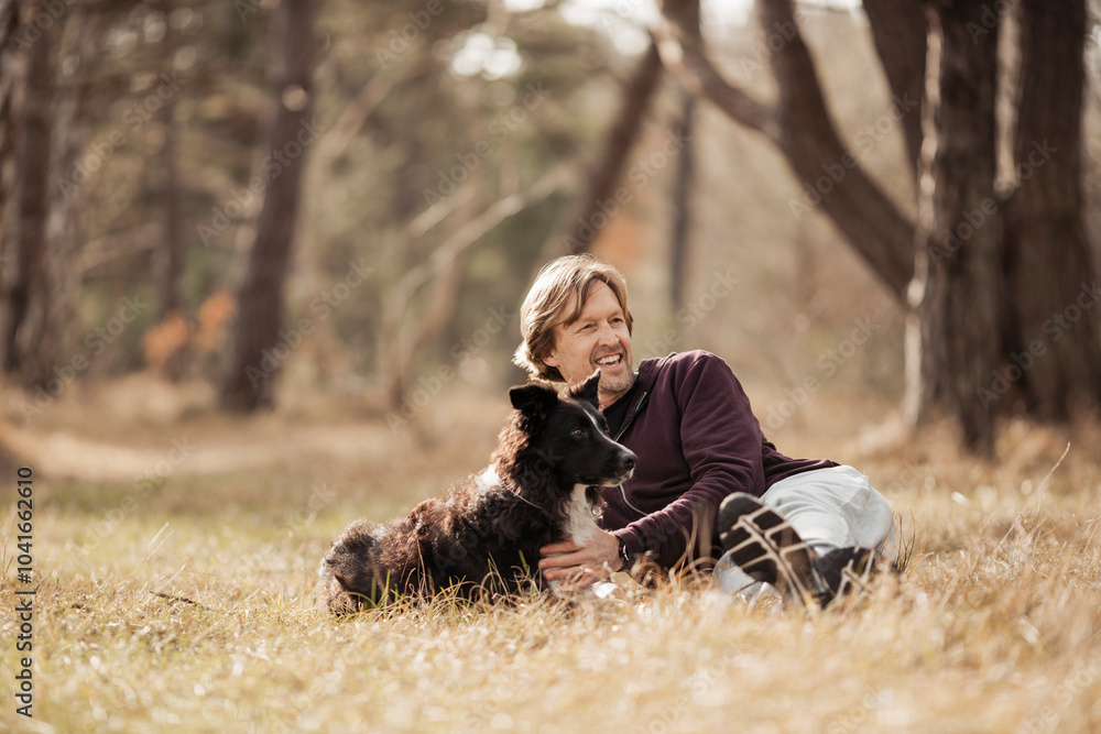 Mature man spending time with his dog in the forest Mature man spending time with his dog in the forest