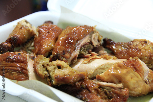 Grilled chicken cut into pieces ready to eat in a foam box.