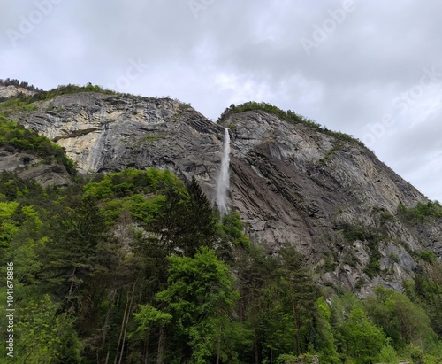 Arpenaz waterfall, one of France highest cascade in Haute Savoie in springtime with impressif cliff of Giffre Massif mountain, alpine landscape photo