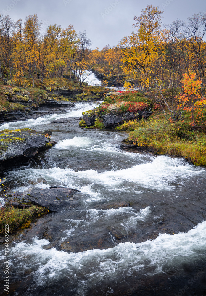 A beautiful autumn landscape of rocky mountain river in Northern Norway. Seasonal scenery of Scandinavia. A beautiful autumn landscape of rocky mountain river in Northern Norway. Seasonal scenery of Scandinavia.