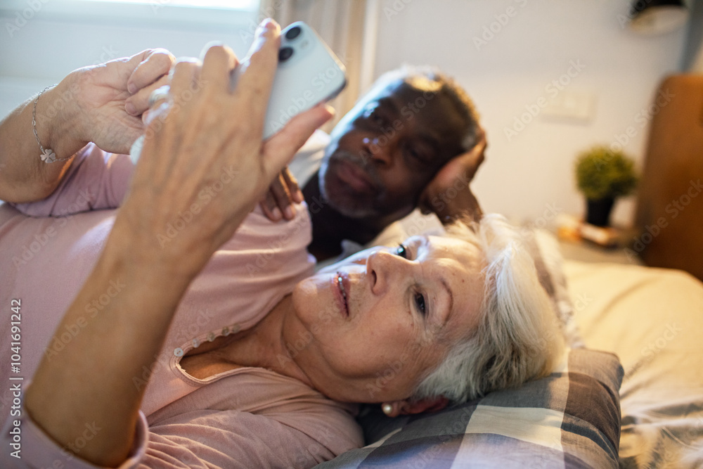 Happy senior couple relaxing in bed at morning Happy senior couple relaxing in bed at morning