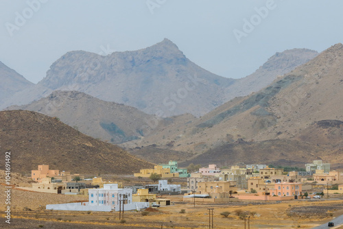 A tranquil village in Oman nestled among the rugged mountains showcasing traditional architecture and the serene landscape during the day