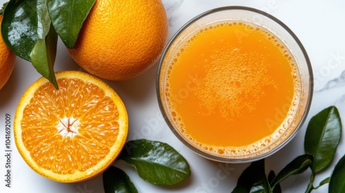 Erfrischendes Glas frisch gepresster Orangensaft mit ganzen Orangen und grünen Blättern photo