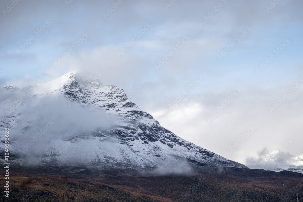 A beautiful autumn landscape with snowy mountain tops in Northern Norway. Seasonal scenery of Scandinavia. A beautiful autumn landscape with snowy mountain tops in Northern Norway. Seasonal scenery of Scandinavia.