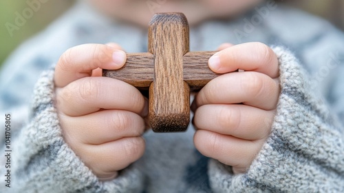 Kind hält handgefertigtes Holzkreuz für religiöse Frühlingsfeier photo